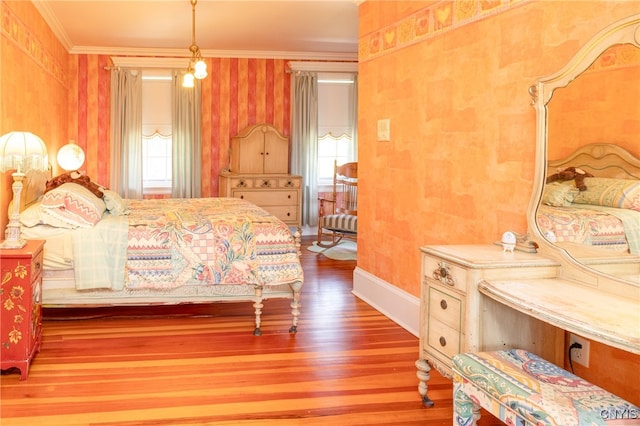 bedroom featuring ornamental molding, hardwood / wood-style flooring, and a chandelier