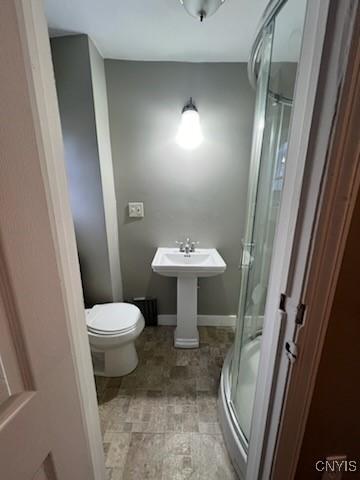 bathroom featuring walk in shower and toilet