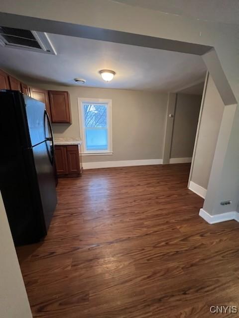 kitchen featuring black refrigerator and dark wood-type flooring