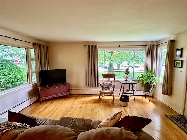 living room with plenty of natural light, hardwood / wood-style floors, and a baseboard radiator