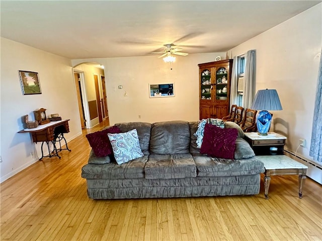 living room featuring ceiling fan, baseboard heating, and light hardwood / wood-style flooring