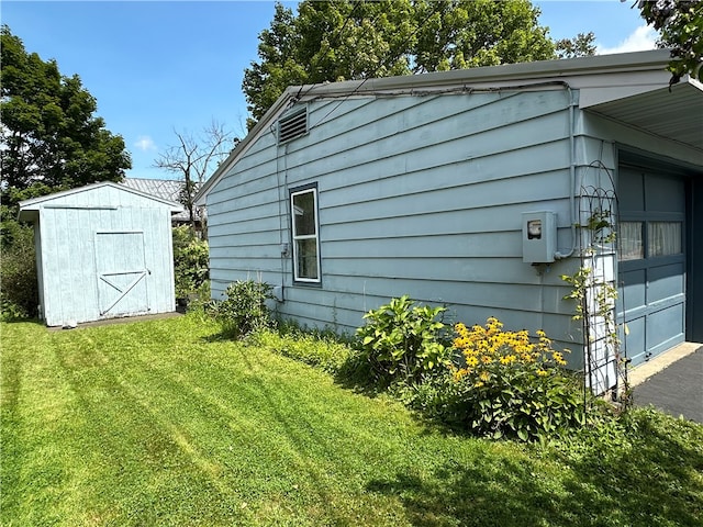 view of home's exterior with a lawn, a garage, and a storage shed