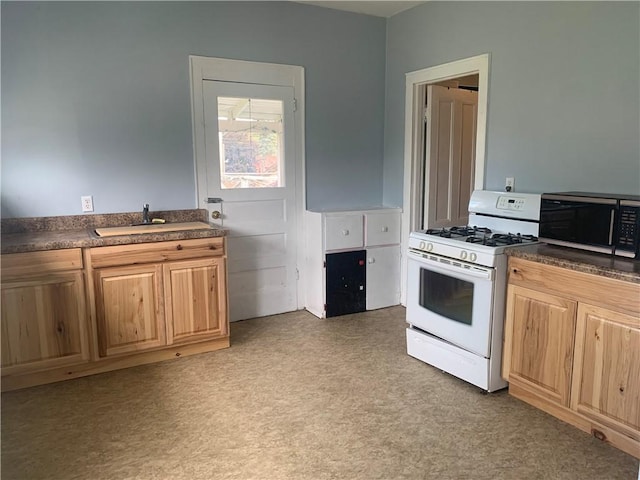 kitchen featuring sink and white range with gas stovetop