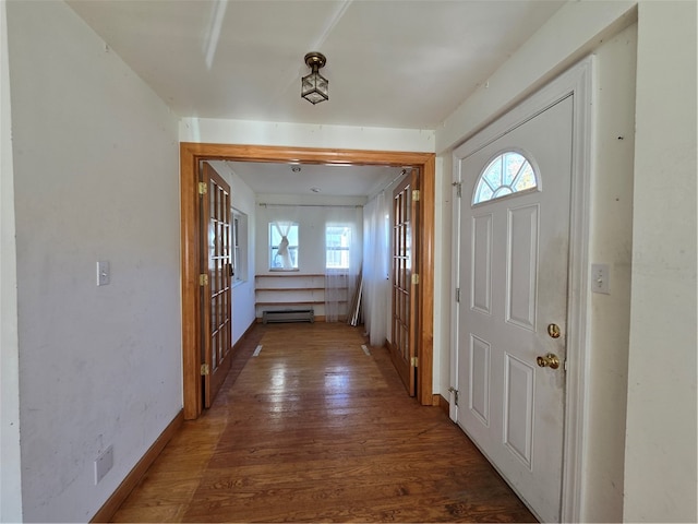 interior space featuring a wealth of natural light, baseboard heating, and dark hardwood / wood-style flooring