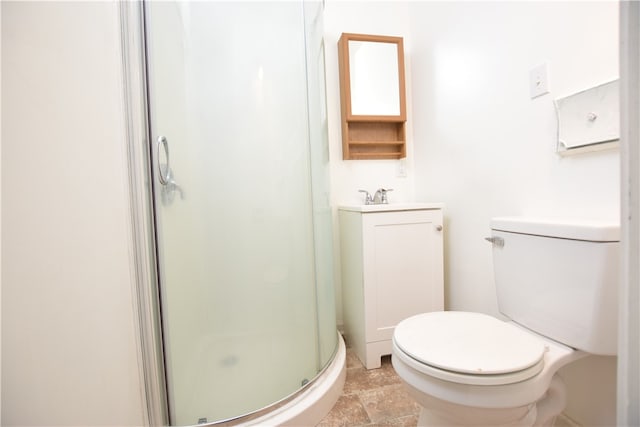 bathroom with toilet, vanity, and a shower with shower door