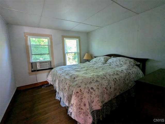 bedroom with cooling unit and dark hardwood / wood-style floors