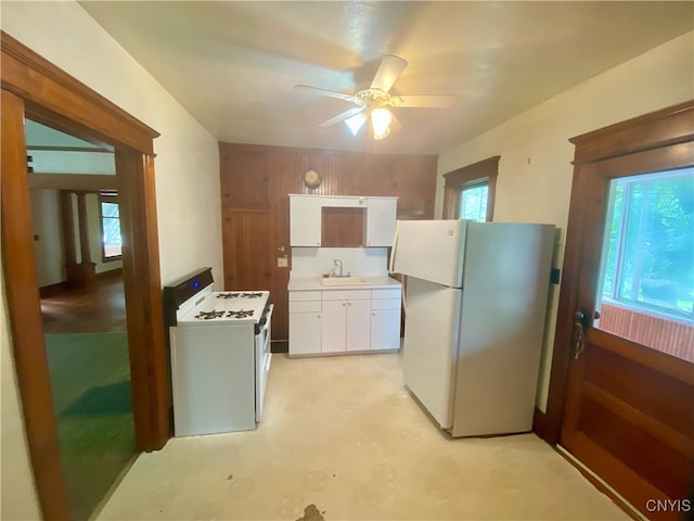 kitchen featuring white cabinets, sink, white appliances, and a wealth of natural light