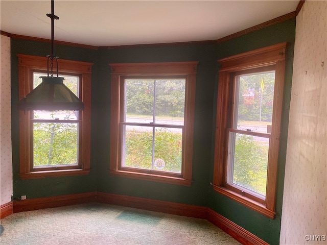 unfurnished dining area with ornamental molding and carpet floors