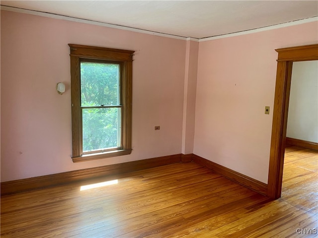 spare room featuring crown molding and light hardwood / wood-style flooring