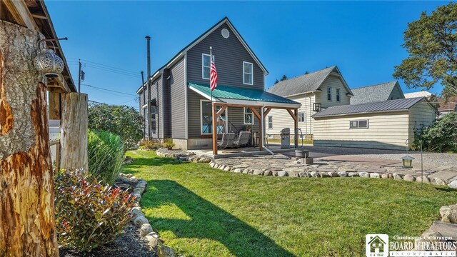 rear view of property featuring a patio area and a lawn