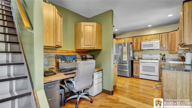 interior space featuring light wood-type flooring, built in desk, and sink