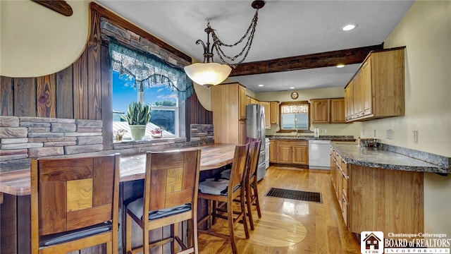 kitchen with light wood-type flooring, plenty of natural light, stainless steel appliances, and decorative backsplash