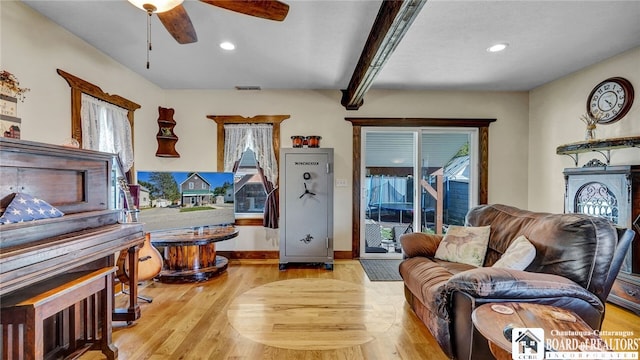 living room featuring beam ceiling, ceiling fan, and light hardwood / wood-style floors