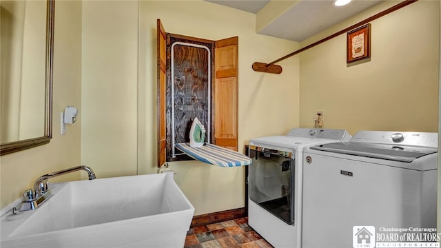 clothes washing area featuring washing machine and dryer and sink