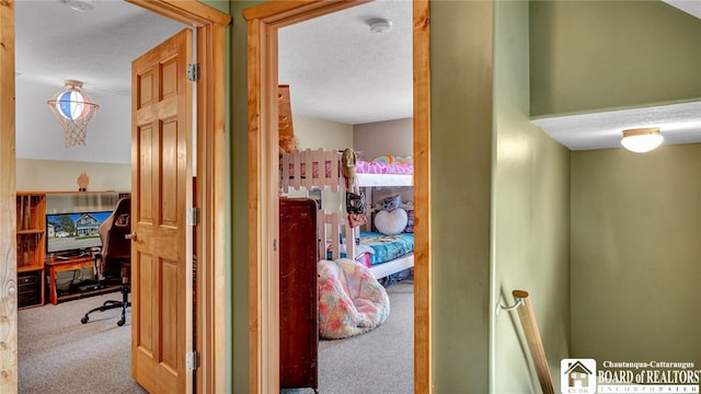 corridor featuring a textured ceiling and carpet floors