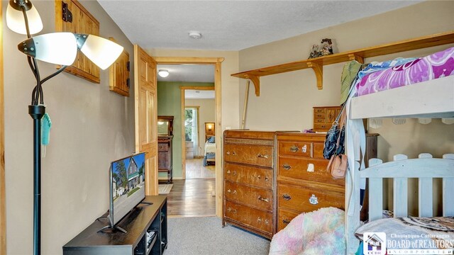 bedroom with light hardwood / wood-style floors and a textured ceiling