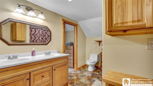 bathroom with vanity, toilet, and vaulted ceiling