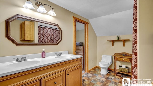 bathroom with lofted ceiling, vanity, and toilet