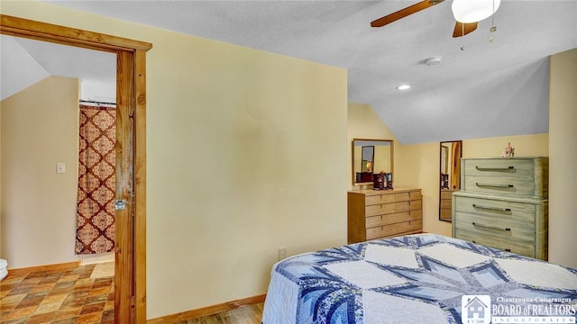 bedroom featuring vaulted ceiling, a textured ceiling, and ceiling fan