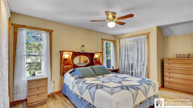 bedroom featuring multiple windows, ceiling fan, and hardwood / wood-style floors