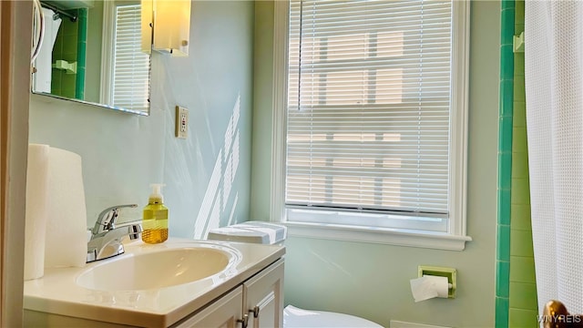 bathroom with a shower with shower curtain, toilet, and vanity