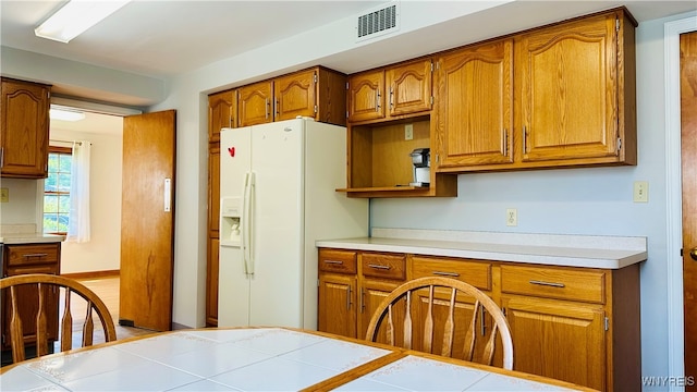 kitchen featuring white refrigerator with ice dispenser