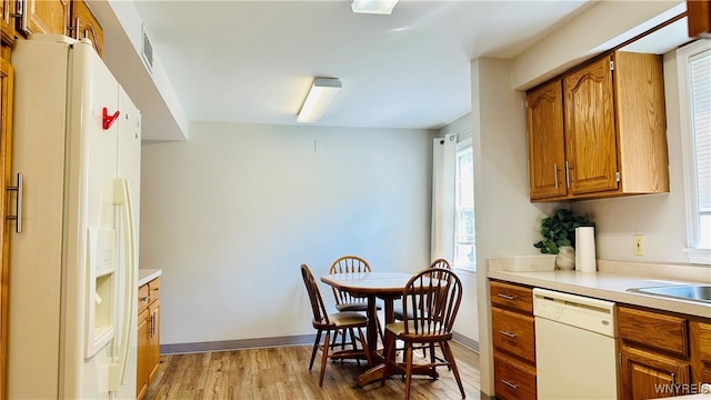 kitchen with white appliances and light hardwood / wood-style floors