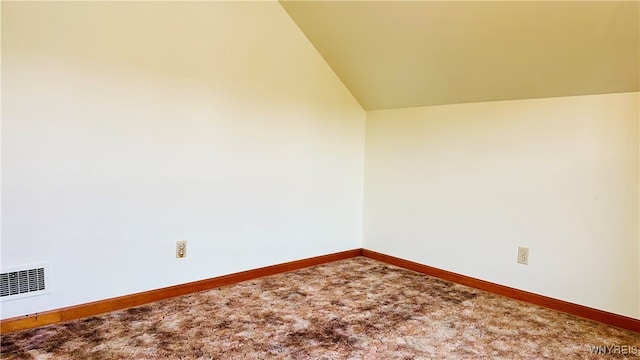 unfurnished room with vaulted ceiling and carpet