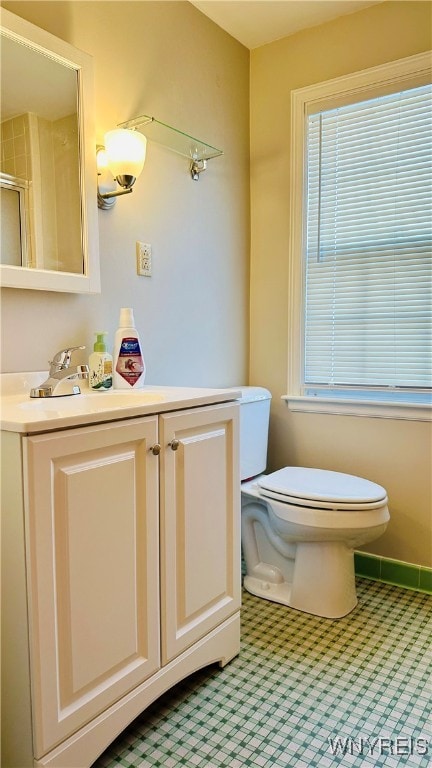 bathroom featuring vanity, toilet, tile patterned floors, and a shower with door