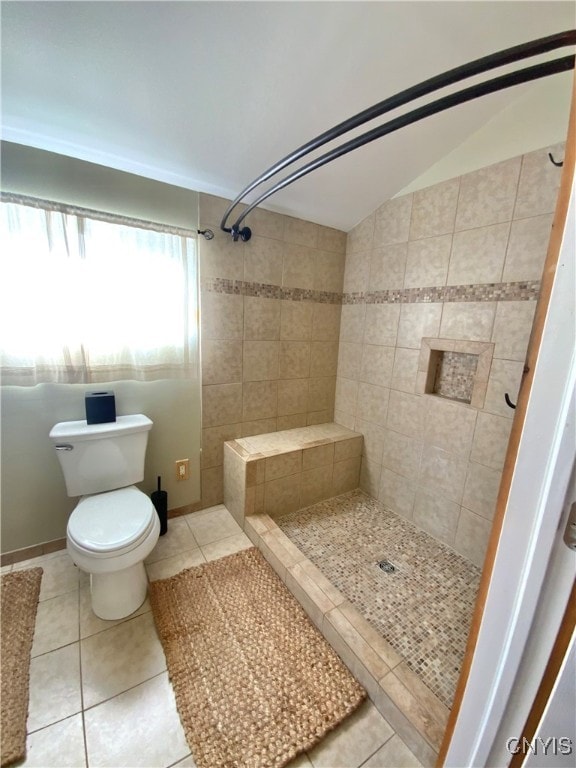 bathroom featuring tile patterned flooring, a shower, toilet, and vaulted ceiling