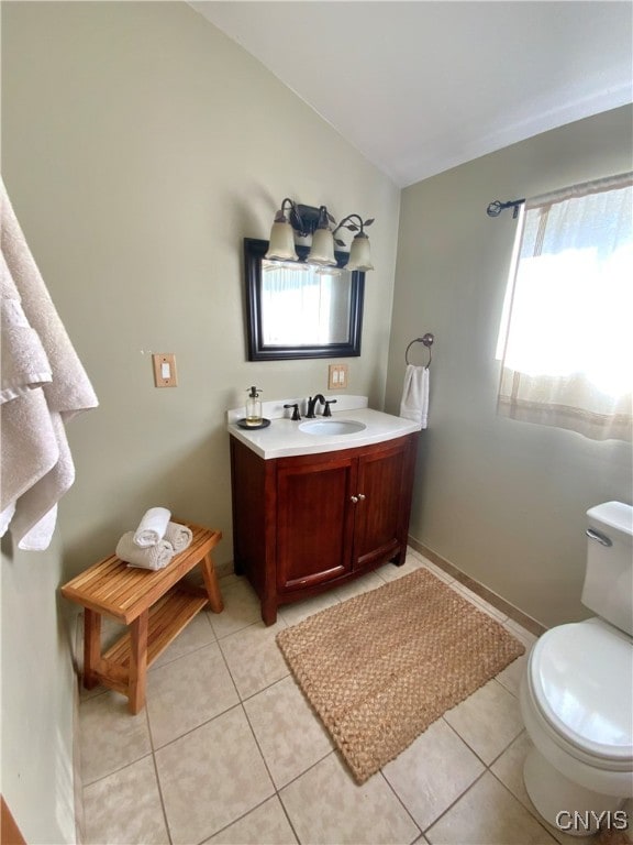 bathroom featuring vanity, toilet, a healthy amount of sunlight, and tile patterned floors