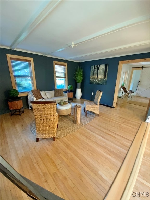 living room with beamed ceiling and light hardwood / wood-style floors