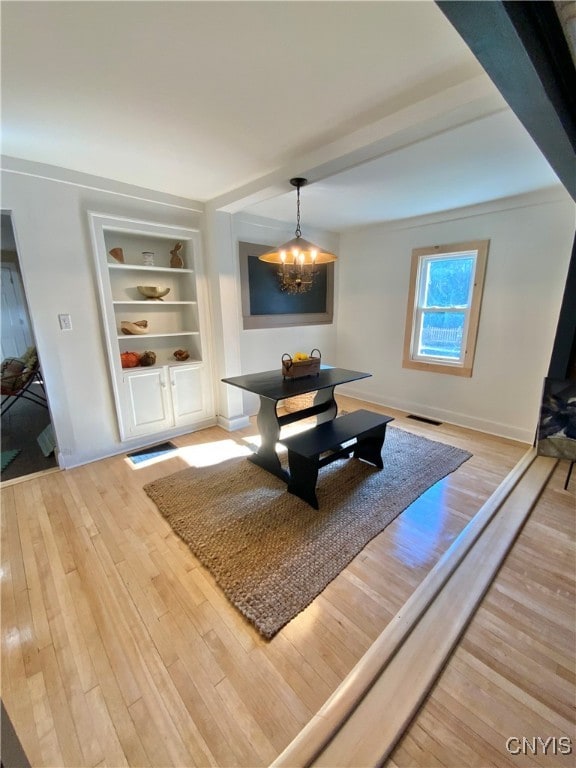 living room featuring hardwood / wood-style flooring and an inviting chandelier