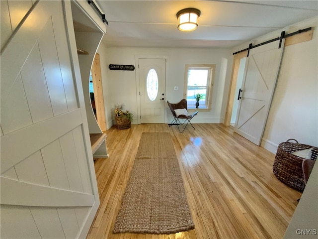 entrance foyer featuring light wood-type flooring and a barn door