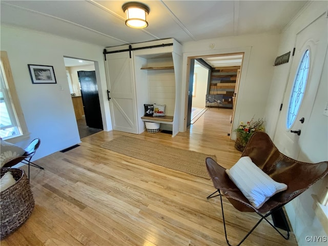 interior space with a barn door and light hardwood / wood-style floors