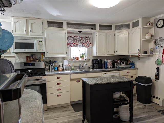 kitchen featuring white appliances, light hardwood / wood-style floors, sink, decorative backsplash, and baseboard heating