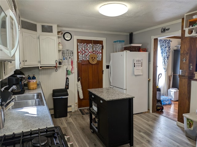 kitchen featuring ornamental molding, sink, wood-type flooring, and white appliances