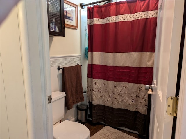 bathroom with toilet, a shower with shower curtain, and hardwood / wood-style floors