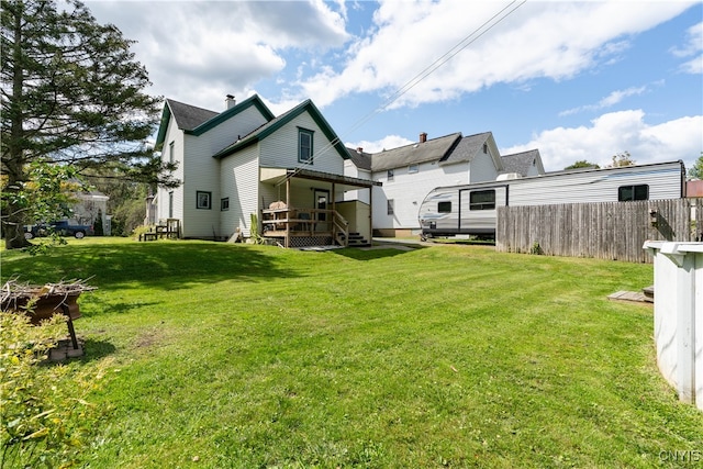 rear view of property featuring a deck and a lawn