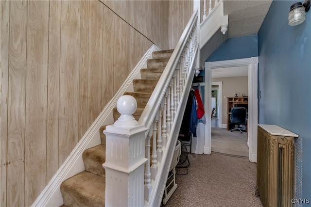 stairway with wood walls and carpet