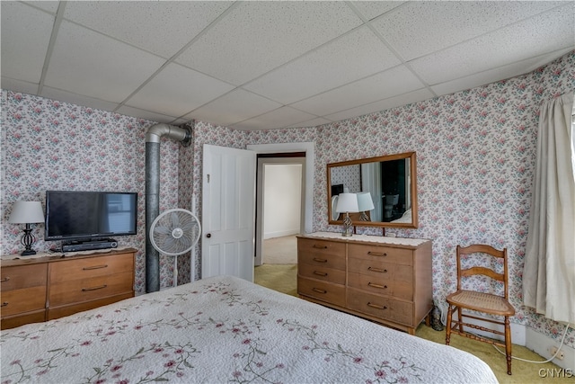 bedroom featuring a paneled ceiling and a wood stove