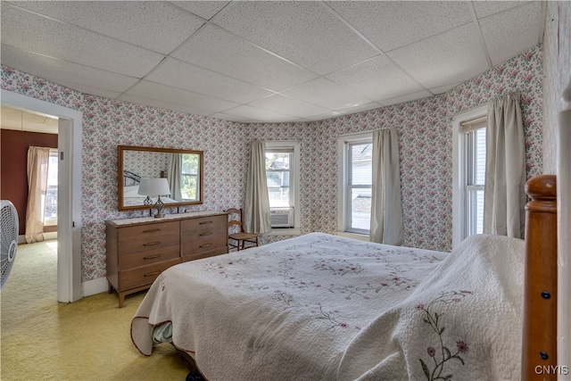 bedroom with light colored carpet and a drop ceiling