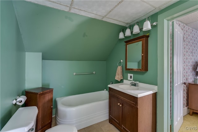 bathroom with toilet, tile patterned floors, vanity, a paneled ceiling, and a bathtub