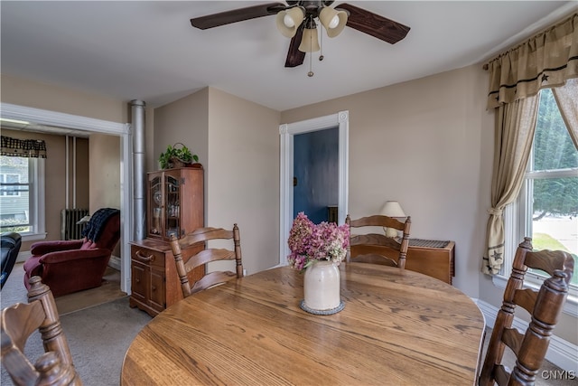 carpeted dining area featuring ceiling fan and plenty of natural light