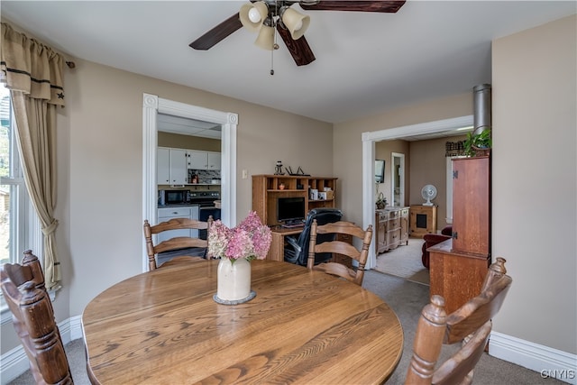 carpeted dining area featuring ceiling fan