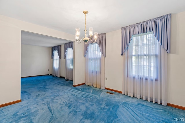 unfurnished dining area featuring a wealth of natural light, carpet flooring, and an inviting chandelier