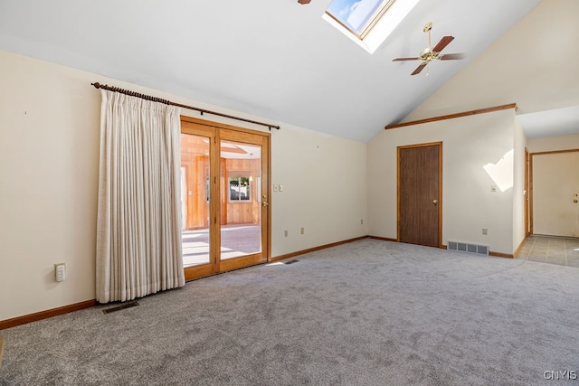 carpeted empty room with high vaulted ceiling, a skylight, and ceiling fan