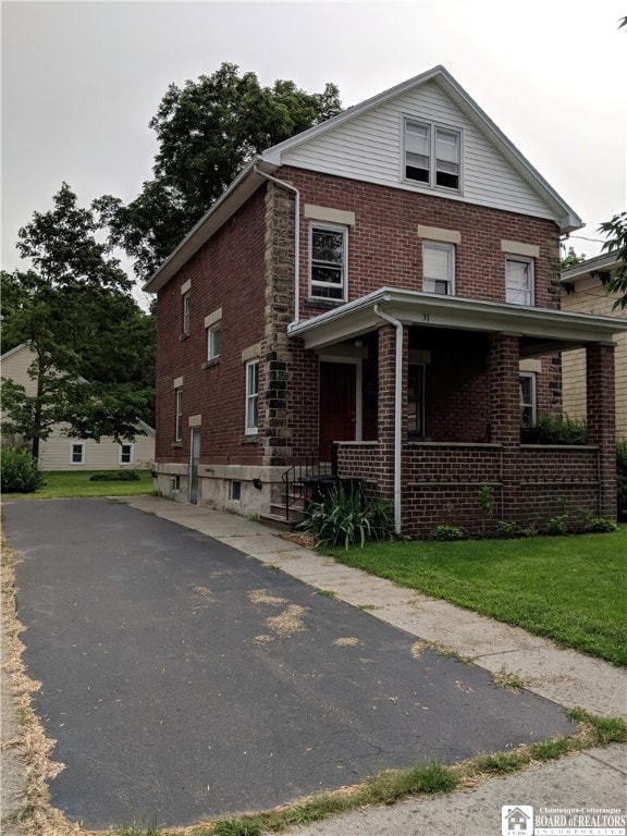 view of front facade featuring a front yard and covered porch