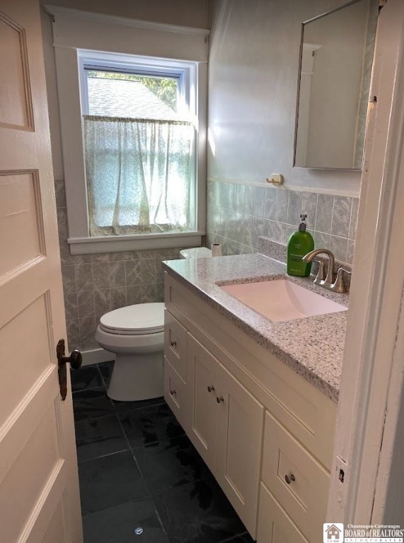 bathroom featuring vanity, tile patterned flooring, tile walls, toilet, and decorative backsplash