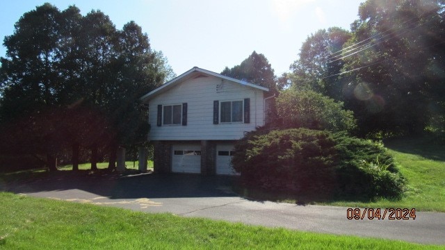 view of front of property with a garage and a front lawn